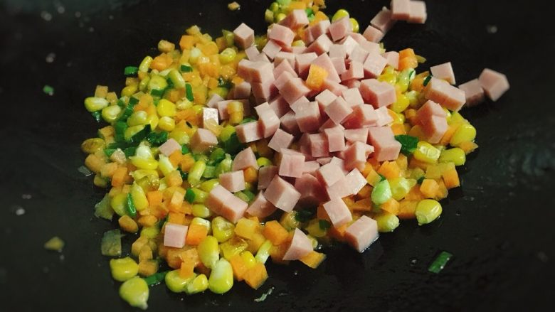 五彩玉米火腿炒饭,再加入火腿丁。