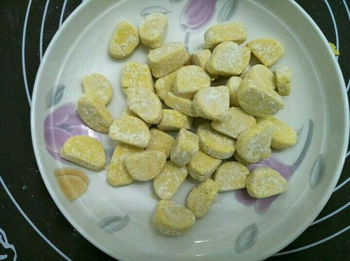 南瓜芋圆双薯糖水,放入盘中并洒上适量的木薯淀粉,让每个小块到粘上淀粉,不粘连。