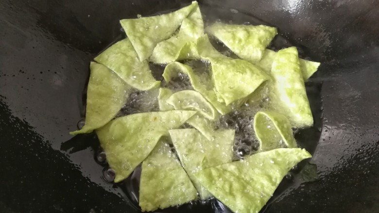 春节零食~翡翠麻叶,把三角面片一片一片的放入锅中小火炸,及时用筷长翻拨几次