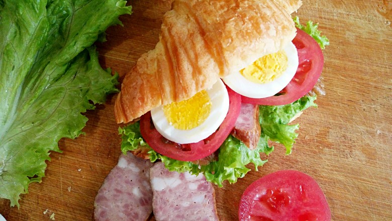 可颂三明治,将<a style='color:red;display:inline-block;' href='/shicai/ 13324'>可颂</a>从侧面切开，不要切断。然后夹进生菜，香肠，西红柿和鸡蛋就OK啦。喜欢吃沙拉酱或千岛酱的亲们还可根据自己的口味在里面添加。