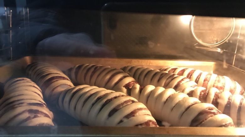 毛毛虫豆沙面包,送入提前预热好的烤箱中层上下火175度25分钟,上色后立即加盖锡纸