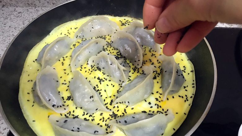 煎饺卧蛋,待蛋液表面凝固,撒上黑芝麻