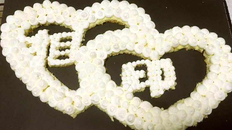 心心相印蛋糕,在蛋糕上均匀的挤上奶油,相印两个字用的小号圆形裱花嘴