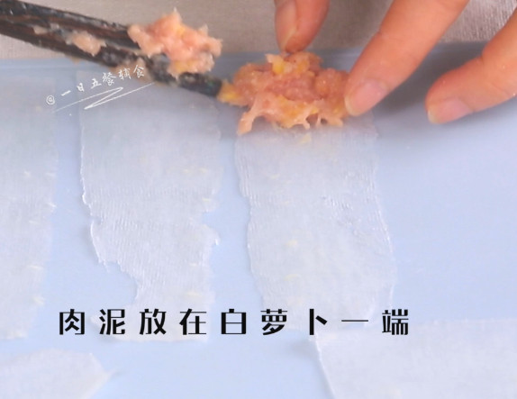 肉末萝卜卷,肉泥放在白萝卜一端,卷起来。