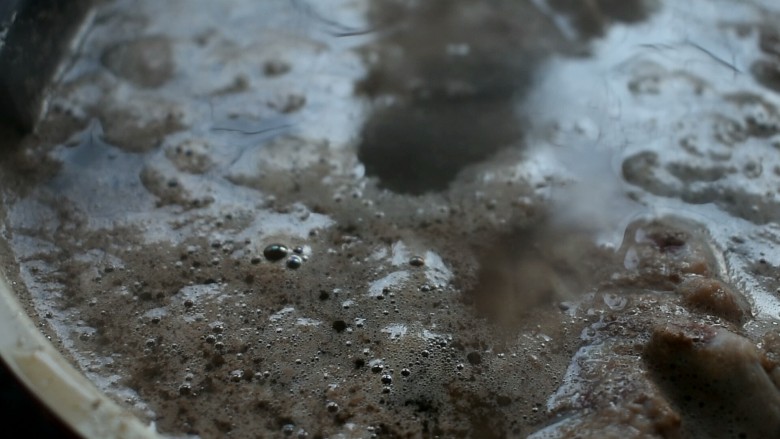 羊蝎子火锅,水开撇去浮沫,将羊蝎子用温水洗干净