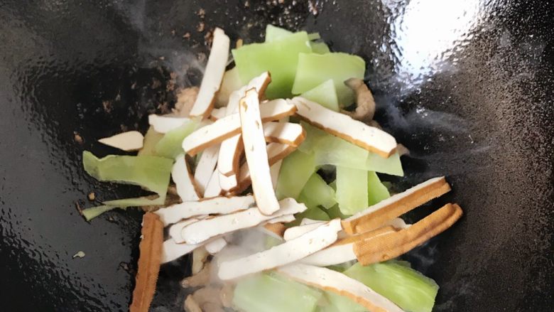 莴笋廋肉豆腐干,翻炒的肉丝变色后，莴笋和豆腐干下锅翻炒