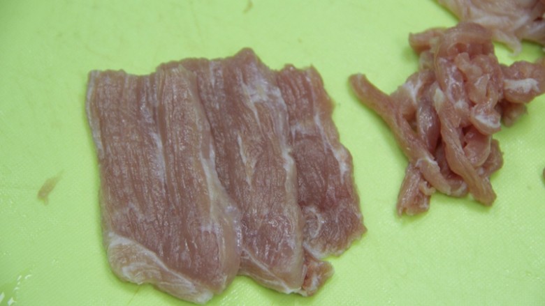 餐桌上最抢眼的一道菜——京酱肉丝,猪肉切成小条,顺着纹路切