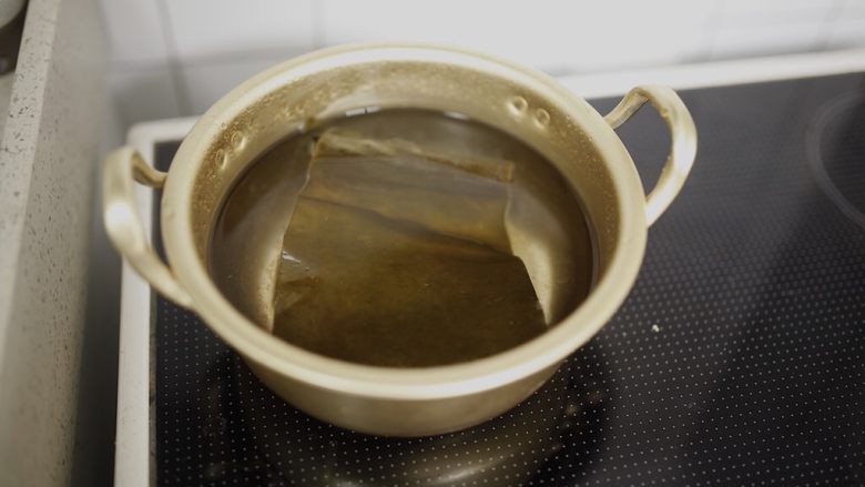 鱼饼年糕锅,开中小火煮10分钟后转大火煮沸。煮沸后就把昆布夹出来,如果一直留在汤里煮,昆布会出杂质。