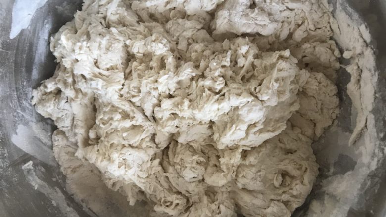 发面芝麻糖饼,将酵母水加入面粉中,用筷子搅拌成絮状。