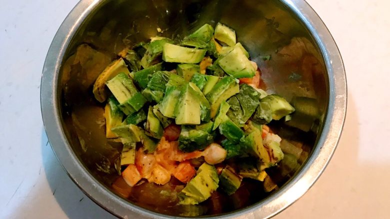 牛油果焗虾仁,把调好味的胡萝卜丁和虾仁放入一个大点儿的盆中,加入牛油果丁,调匀