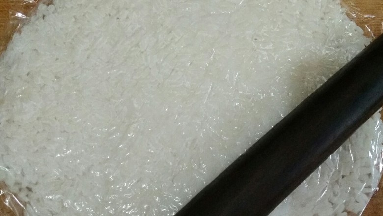 锅巴肉片(鸡胸肉版),米饭用保鲜膜包起来,用擀面杖擀成薄饼。