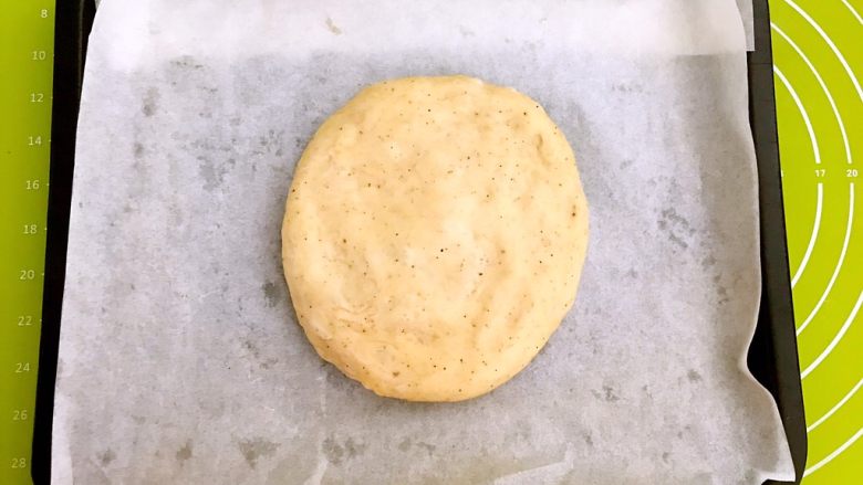 新疆烤馕,烤盘里放上牛油纸,取一块面,放在牛油纸上用手压扁