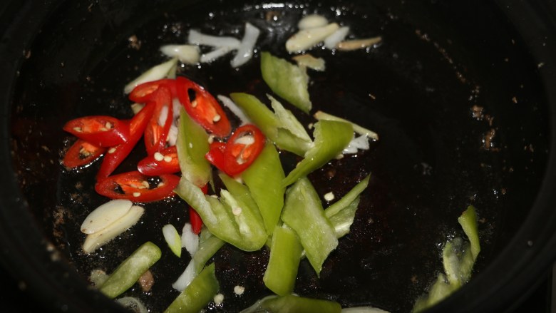 爆炒猪肝,锅底留底油,爆香葱姜蒜,放入红绿辣椒翻炒。
