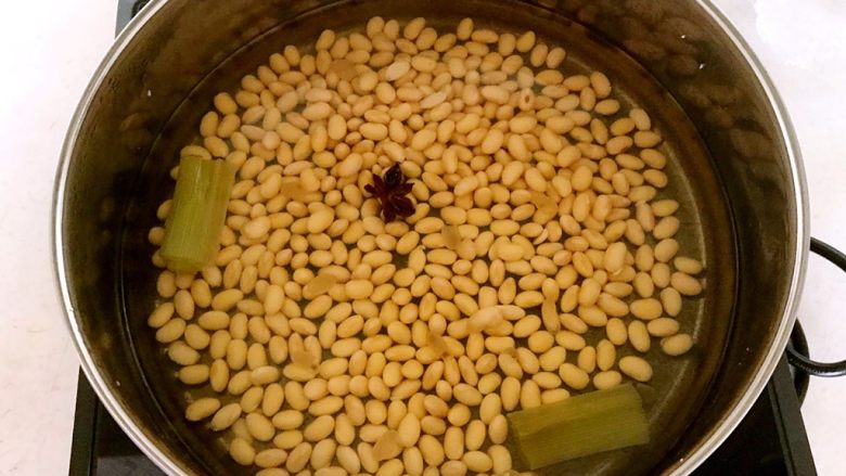 金豆腊肠雪里蕻,把泡好的黄豆放入锅中,加入冷水,加入葱段和八角,大火烧开后小火煮15分钟