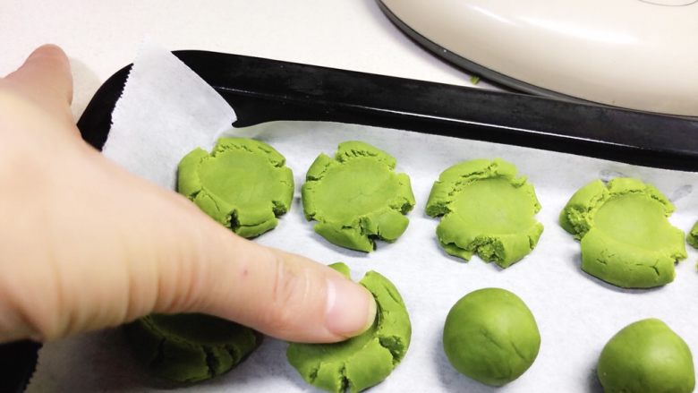 玛格丽特饼干（抹茶味）,用大拇指在每个面团上轻轻的随意按压一下。