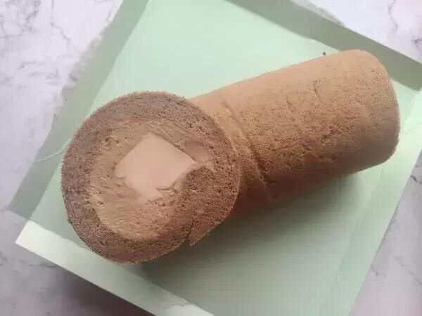Q弹耶冻树桩蛋糕,取出冷藏定型好的蛋糕卷,将两端切整齐,再切下约4、5厘米厚的一段,切面朝上放在蛋糕卷上面