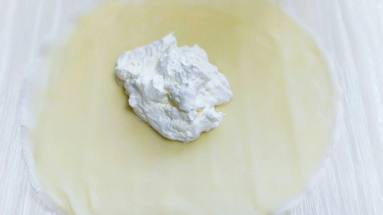 春节餐桌上不可缺少的芒果班戟,取一张皮,放入打发的奶油。