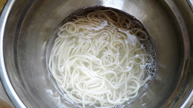 鸡蛋炸酱面,锅里添入适量清水,烧开,放入面条,将面条煮熟,捞出过凉水,这样面更清爽,更劲道,