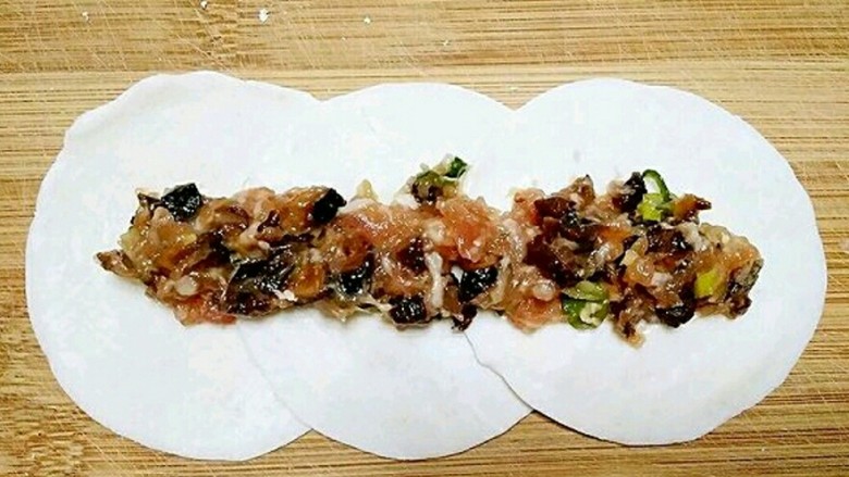 文艺吃货的花式蒸饺,按自己想做蒸饺的大小选择用几张饺子皮,为了方便我家妹纸吃,我用了3张。把饺子皮搭边叠起,中间放上馅。