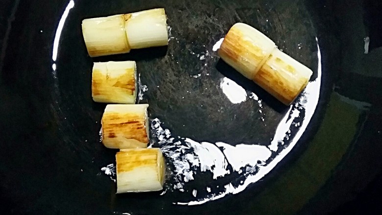 葱烧海参,另取一锅,加适量的油烧至5分热时下葱白段,小火煎至葱白焦黄色。