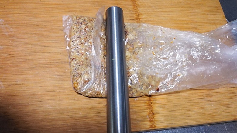 老味道—核桃酥, 烤好的核桃放入食品袋,先用擀面杖慢慢敲碎,再用擀面杖擀。喜欢吃大颗粒的就敲碎就可以了。