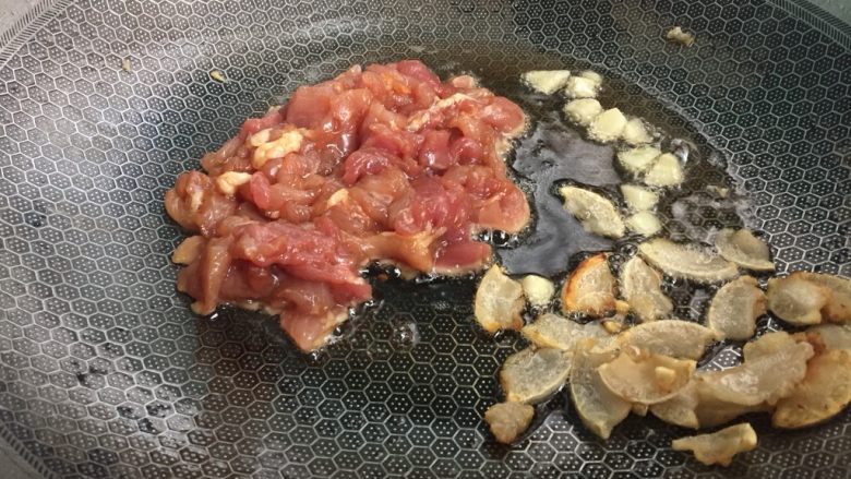 家常菜青椒炒肉,先后加入大蒜和肉翻炒
