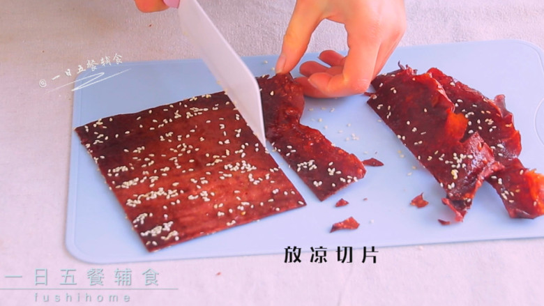 猪肉脯,取出晾凉之后切成片。边缘比较薄比较脆,边切边吃~。