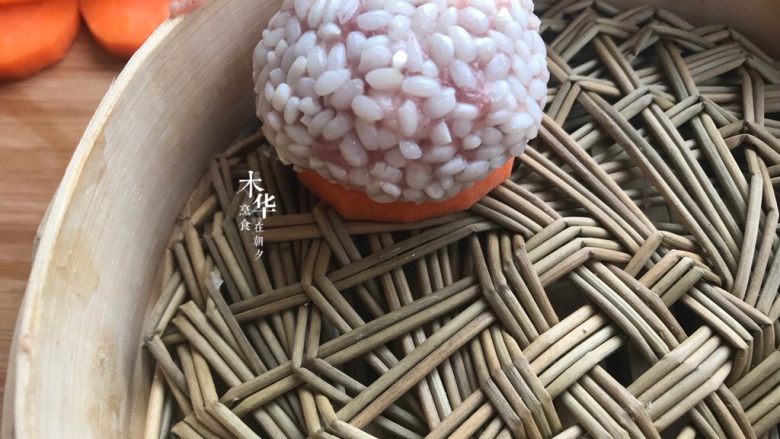 珍珠丸子,取一片胡萝卜片,把肉丸放入蒸笼。也可以垫土豆片,菜叶,如果觉得麻烦,可以只涂油就好,不然会粘底的。