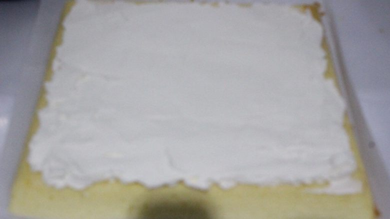 草莓蛋糕卷~UKOEO 风炉制作,蛋糕两头斜切掉一点,在凉透的蛋糕卷上抹奶油,靠近自己的地方抹厚一点。其余三边留一点空不要抹。