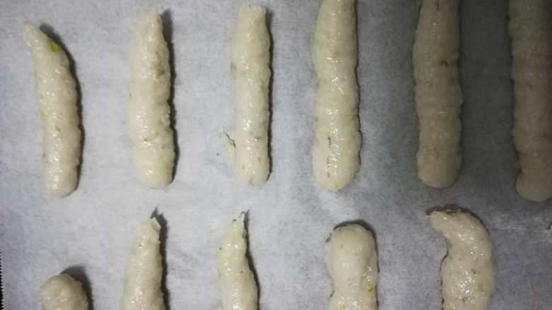 吃了就停不下来,鲜香酥脆的宝宝虾条,烤箱170度预热, 虾泥挤到铺好油纸的烤盘中,间距是虾条粗细的1.5倍。
