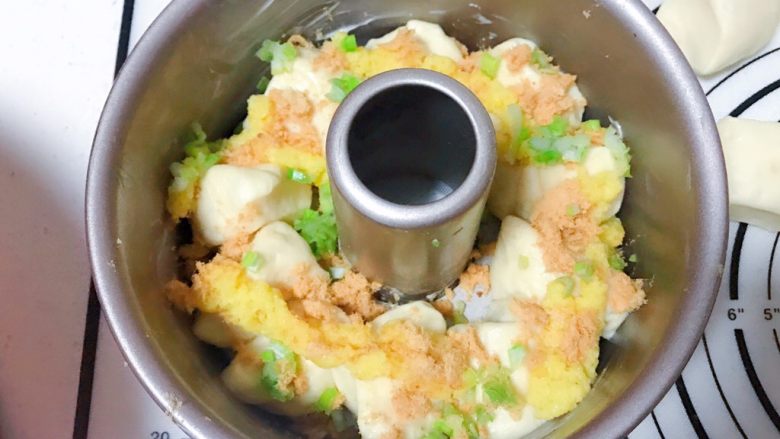 爆浆肉松面包,取一个8寸中空模具,铺满一层切好的面团,挤上沙拉酱,撒上肉松和葱花