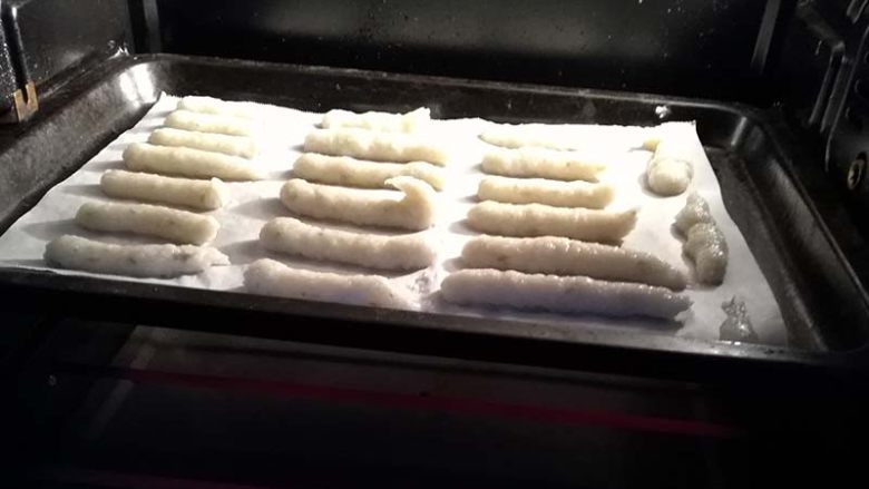 吃了就停不下来,鲜香酥脆的宝宝虾条,放入烤箱中层,调至上下火150度,烤35分钟。