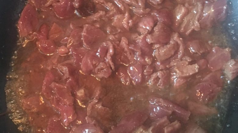 蒸面条,倒入腌制的牛肉,翻炒