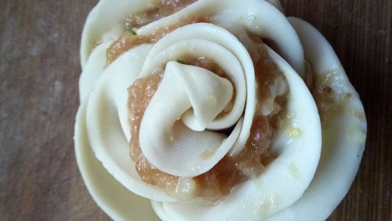 玫瑰花饺,卷好后,可以再修整下“花瓣”,这样
一个玫瑰花饺子就做好了,