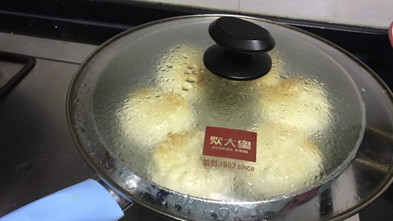 金牌牛肉煎包,倒入牛肉饼高度1/3左右的水，盖好锅盖。转中火，焖几分钟至水变少听到啪啪声。