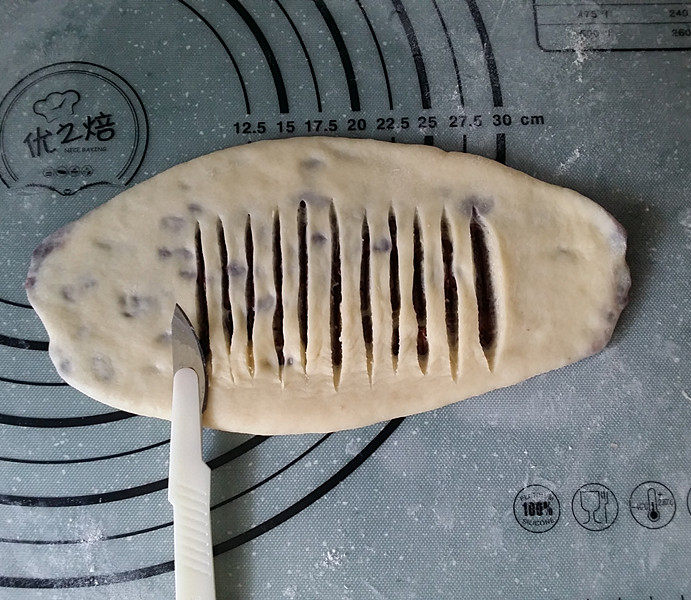 豆沙花瓣面包,用小刀在中间划开多条刀口,且不要划断底部面皮