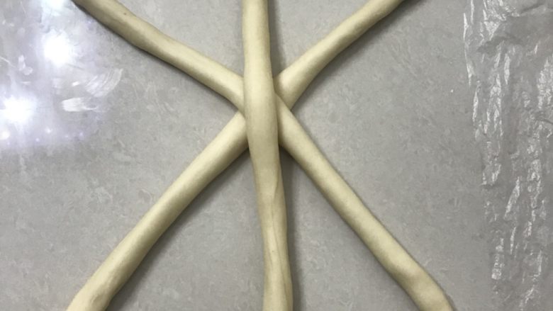 奶香辫子面包,再从第一个开始继续用两手掌搓长,3 个为一组,长途大约30厘米长,像图中这样摆放