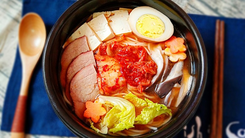 酸辣泡菜面,将煮好的面盛入碗中加入适量面汤,摆上豆腐,牛肉,鸡蛋,蘑菇,辣白菜等即可。