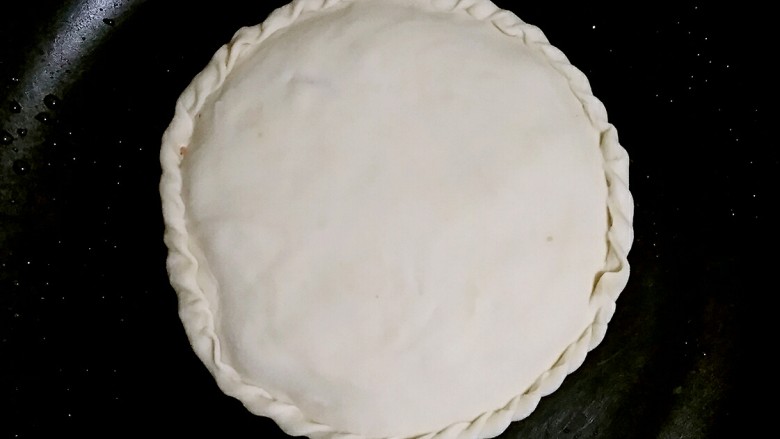 花边馅饼,平底锅预热,把饼入锅,加盖小火烙。