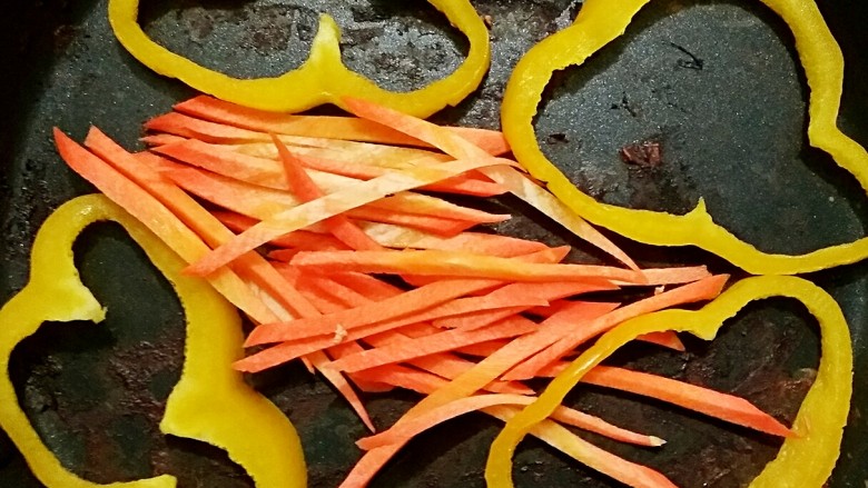 时蔬无油鸡肉卷,鸡柳煎好后，将彩椒圈和胡萝卜丝放入锅中稍微煎一下即可。