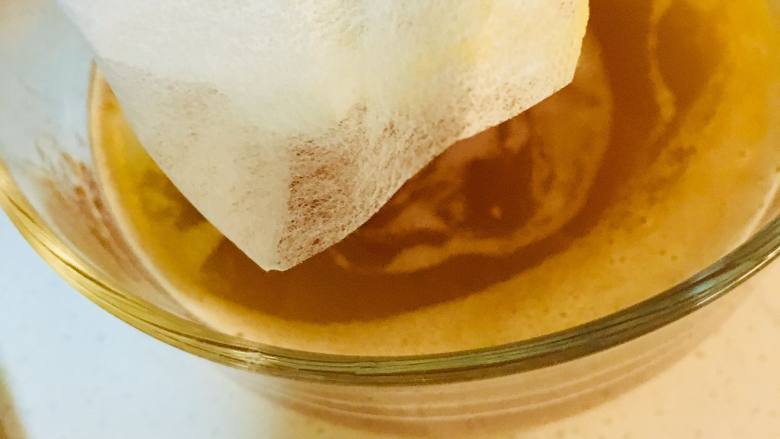 蓝莓酱费南雪,取一个茶包袋,将焦化好的黄油过滤掉沉淀物