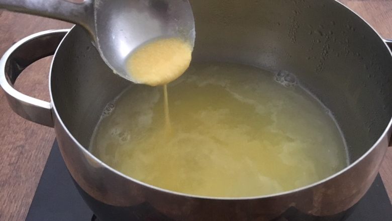 营养早餐 肉末雪菜玉米面粥,水开后调至中火,放入玉米面糊,并轻轻搅动。