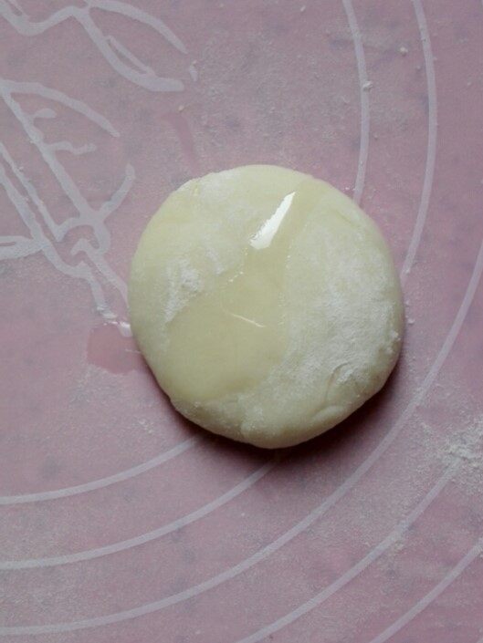 冷藏都不开裂的柔软春饼,取一个剂子,表面滴一滴玉米油,放玉米油是为了防止两个剂子粘在一起