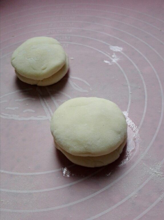 冷藏都不开裂的柔软春饼,把另一个剂子盖在上面,转动一下,使油均匀涂抹在两个剂子中间,按扁