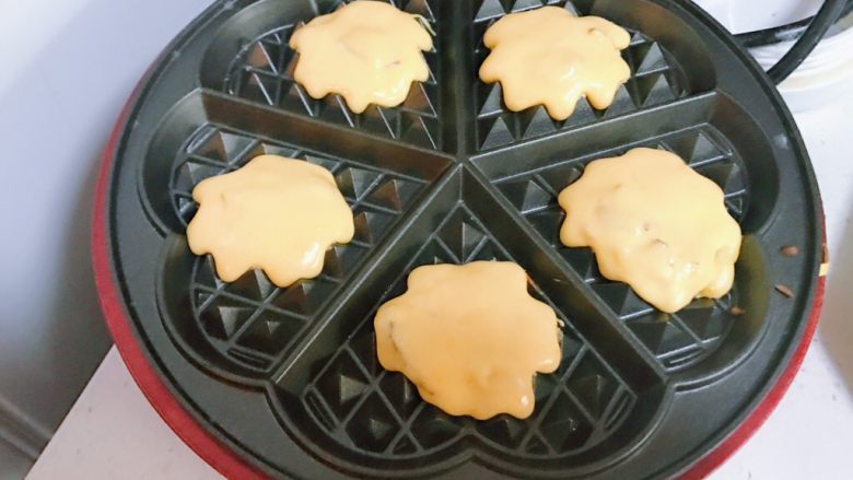 南瓜红枣华夫饼,松饼机预热,用勺子舀一勺面糊放入松饼机后盖上盖子
