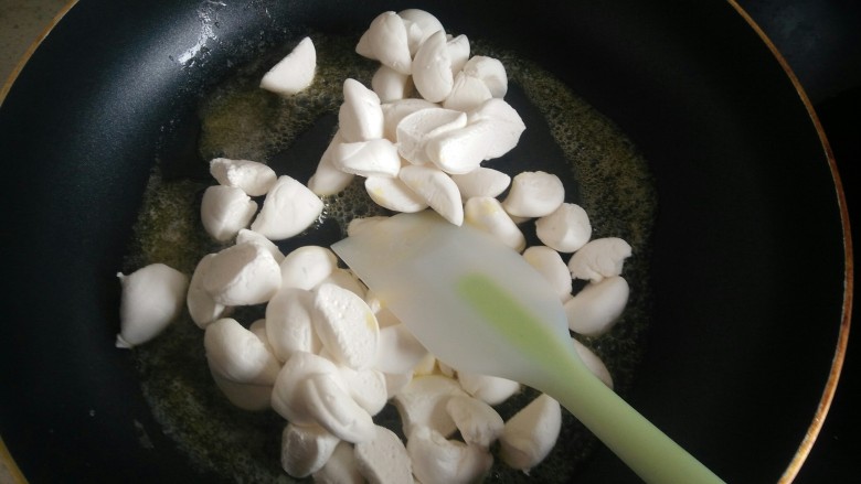 花生味牛轧糖,倒入棉花糖翻炒,边压边翻炒。
