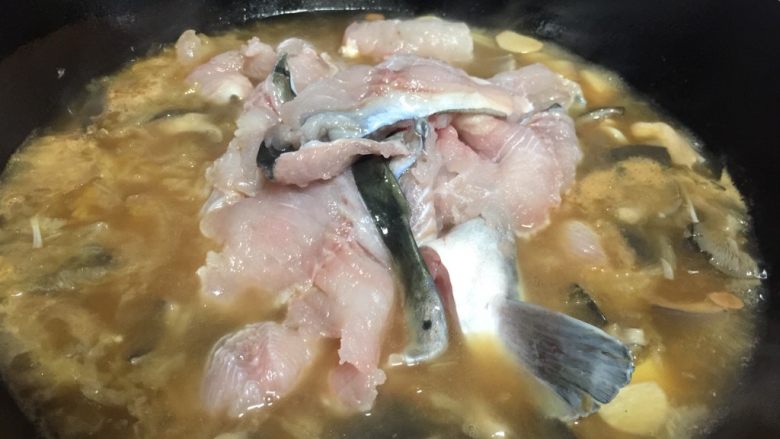家常酸菜鱼,汤烧开后放入鱼肉片