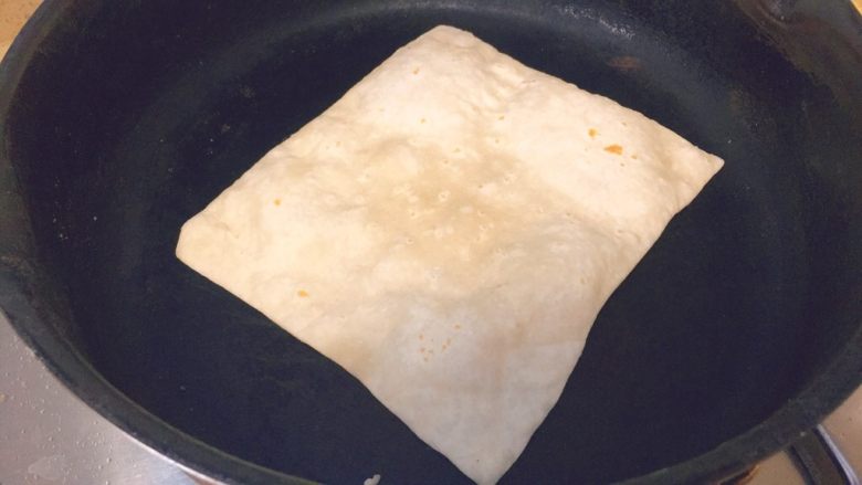 春饼卷土豆丝,然后拿一个不粘的平底锅,起锅,不放油,然后把饼放进去,它会这样变白起泡,鼓起来。
