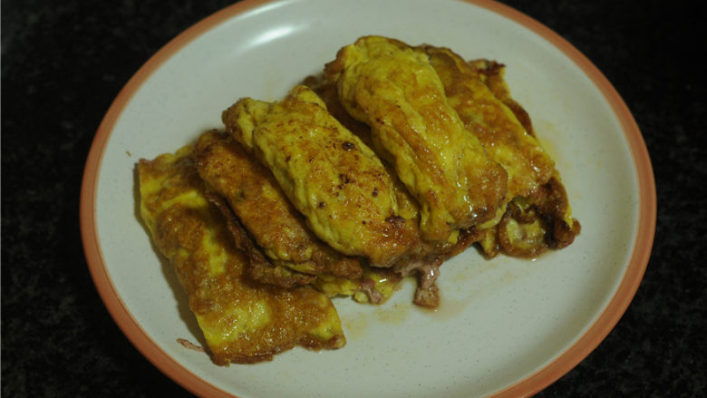 牛肉鸡蛋饺子,每做好一个鸡蛋饺子,可以将它拨到锅沿边,利用锅边的余温将鸡蛋表皮煎成漂亮的焦黄色。剩下的蛋液全部做好后再将它们一起盛出来。