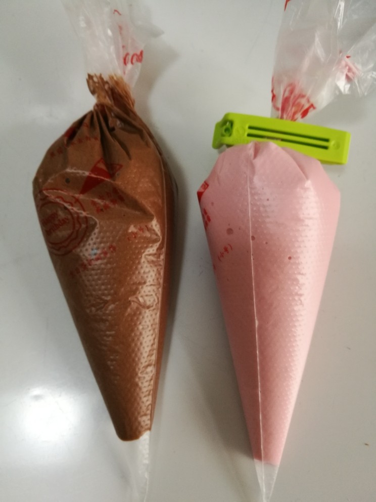 法式马卡龙,装入裱花袋,我同时做了个粉色的,方法一样只是不加可可粉,加了一点粉色素。把可可量换成杏仁粉即可。